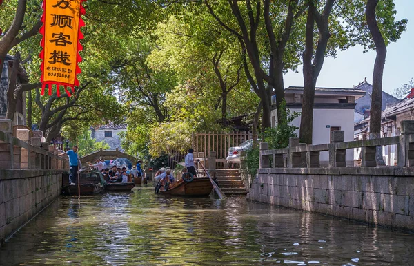 通格利 江苏省 2010年5月3日 运河风景 几艘满载游客的小船在绿叶下造成交通堵塞 红色横幅增加了色彩 岸上住房 — 图库照片