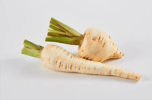 Parsnip. Fresh parsnip. Pasher with parsley against white background. A few fresh parsnips with parsley. Petrushevye grass. Fresh vegetable. — Stock Photo, Image