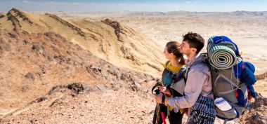 Kaç turist backpackers çöl dağ tepe sırtı ayakta.