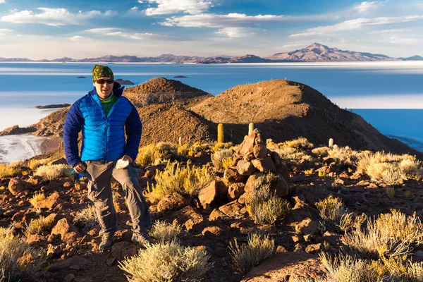 Touristen-Backpacker stehend Berg riesigen Kaktus, salar de uyuni, Bolivien. — Stockfoto