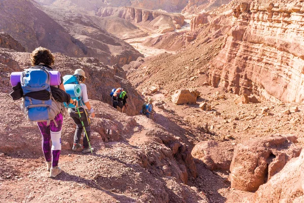 Groupe de personnes descendant randonnée pierre désert sentier randonnée voyage — Photo