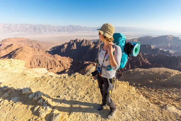 Backpacker young woman standing desert mountain edge canyon view — Stock Photo, Image