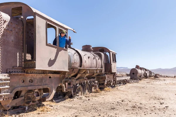 Happy train locomotive driver waving hello, Bolivia trains cemet
