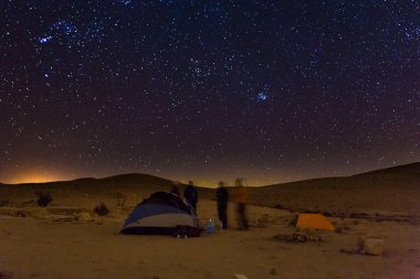 Gece kamp çadırları insanlar konuş, gece yıldızlar gökyüzünde.