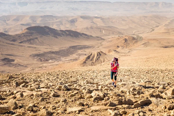 Ung vacker kvinna backpacker stigande sten öken trail, Israel — Stockfoto