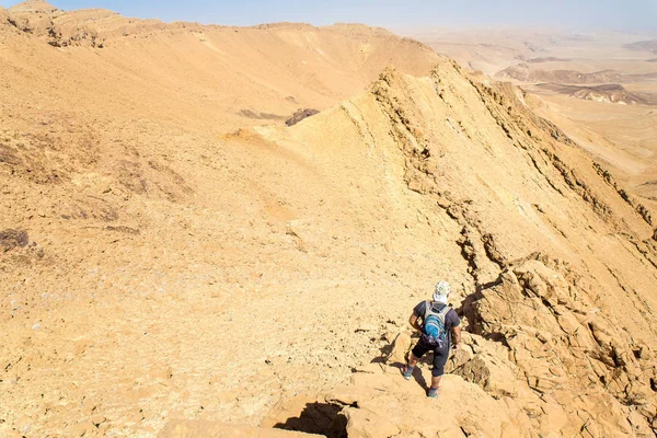 Backpacker turist ständiga öken cliff ridge kanten bergslandskap — Stockfoto