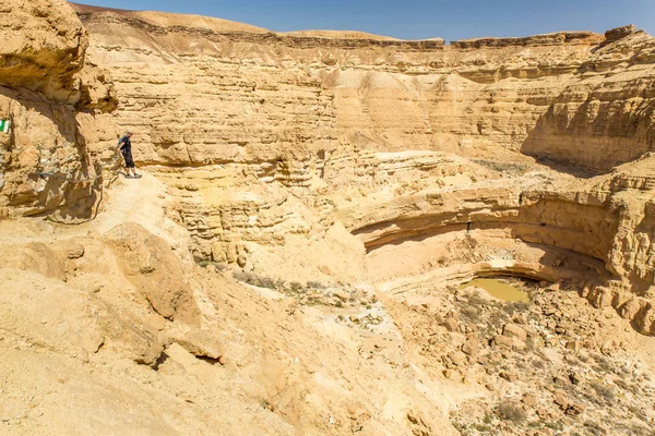 春湖上砂漠山の崖の端に立っている男. — ストック写真