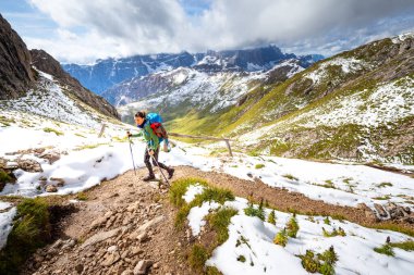 Woman backpacker tourist hiking walking ascending alone mountain trail footpath,   scenic landscape view, South Tyrol alps travel Italy solo Europe tourism. clipart