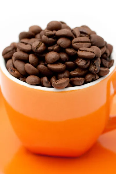 Смажені кавові зерна в апельсиновій чашці — стокове фото