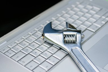 Gümüş bir dizüstü bilgisayarda ayarlanabilir İngiliz anahtarı