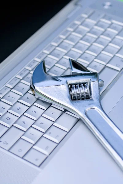 Adjustable wrench on a silver laptop — 스톡 사진