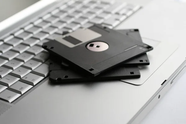 Régi floppy lemezek egy ezüst billentyűzeten — Stock Fotó