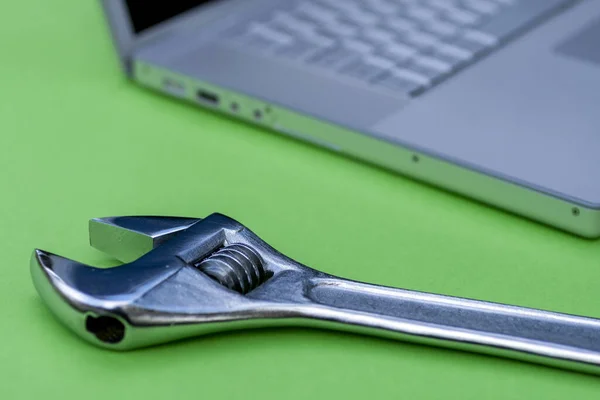 Einstellschlüssel neben einem silbernen Laptop. Computerservice, Wartungsthema. — Stockfoto