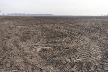 Donmuş toprak ve traktör lastik izleri bir kış günü.