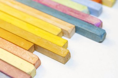 Beyaz arkaplanda renkli pastel boyaların yakın plan görüntüsü.