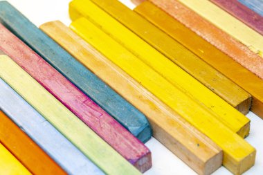 Beyaz arkaplanda renkli pastel boyaların yakın plan görüntüsü.