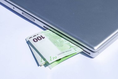 Gümüş bir dizüstü bilgisayarda Euro banknotları.