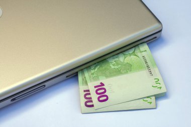 Gümüş bir dizüstü bilgisayarda Euro banknotları.