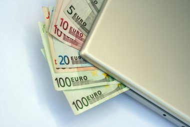 Gümüş bir dizüstü bilgisayarda Euro banknotları.