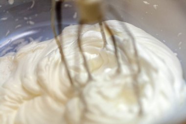 Beyaz yumurta kremasını elektrikli mikserle karıştırmak, kek pişirmek.