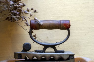 Bej bir duvarın önündeki eski ütü, klasik tema