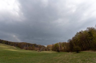 Macaristan 'ın Bankut kenti yakınlarındaki Bukk dağlarındaki bir çayırda bulutlu bir gökyüzü