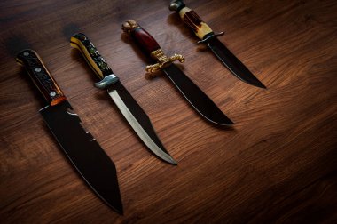 Hunting knives collection on wood table - Aggressive survivor tool clipart