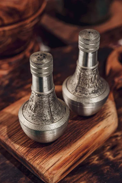 Tahtadaki gümüş tuz ve biber karıştırıcıları.