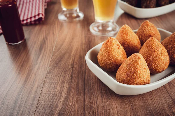 Brezilya aperatifi kızarmış Coxinha de frango ve iki bardak bira.