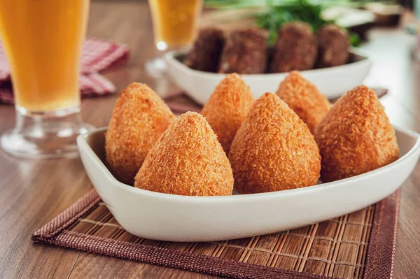Brezilya aperatifi kızarmış Coxinha de frango ve iki bardak bira.