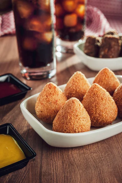 Brezilya aperatifi kızarmış Coxinha de frango, kibbe ve iki bardak meşrubat.
