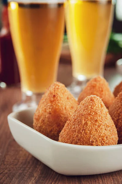 Brezilya aperatifi kızarmış Coxinha de frango ve iki bardak bira.
