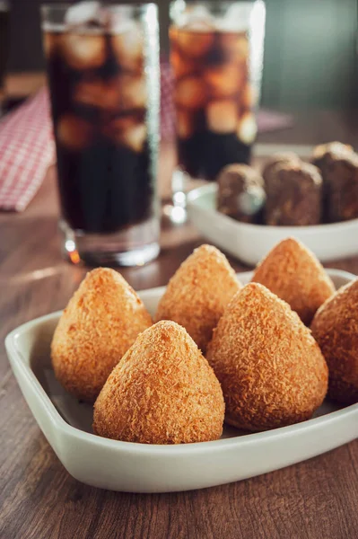 Brezilya aperatifi kızarmış Coxinha de frango, kibbe ve iki bardak meşrubat.