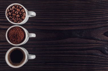 Brezilya kahvesi sıvı, toz ve fasulye siyah bir ahşap üzerinde.