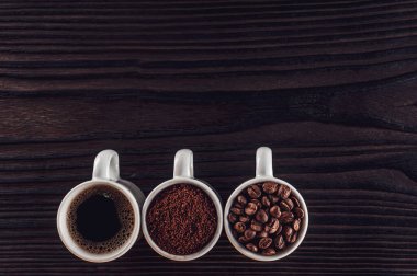 Brezilya kahvesi sıvı, toz ve fasulye siyah bir ahşap üzerinde.