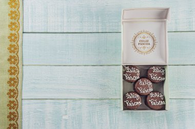 Ballı kurabiyelerin üst görüntüsü çikolata kaplı kutuda Mutlu Paskalyalar - Paes de mel