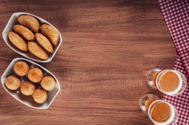 Brezilya aperatifi bol yağda kızartılmış peynir ve iki bardak birayla birlikte sığır kroket Bolinha de queijo ve risolis de carne uzay kopyasıyla üstte.