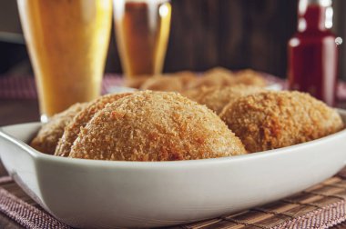 Brezilya usulü aperatif, kızarmış sığır kroketi, iki bardak bira ve acılı sos, Risolis de Carne.