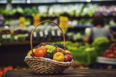 Marketteki ahşap masada sepet ve taze meyve.
