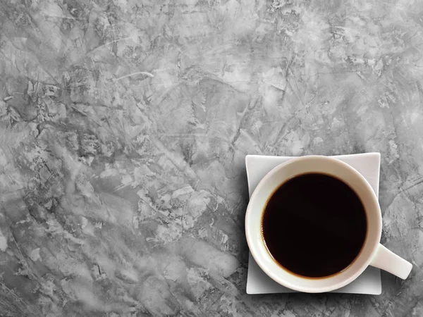 Šálek kávy na pozadí stolu cementu texturou. — Stock fotografie