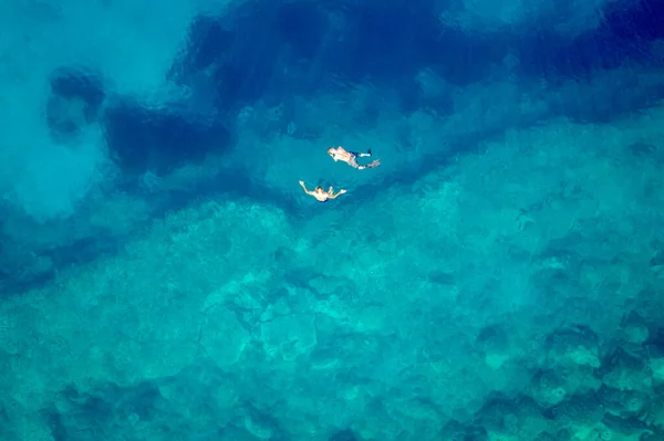 Vista aérea da praia de Trsteno, em Montenegro, perto de Budva, uma bela baía com uma costa rochosa, água azul, pessoas se banham em águas claras — Fotografia de Stock
