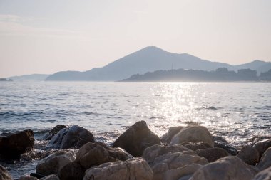 Karadağ 'ın Kamenovo plajında gün batımında taş sahiller