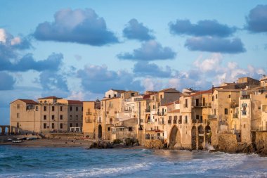 Günbatımında Sicilya kıyı şehri Cefalu 'nun Tyrhenian Denizi ve Ortaçağ evleri.