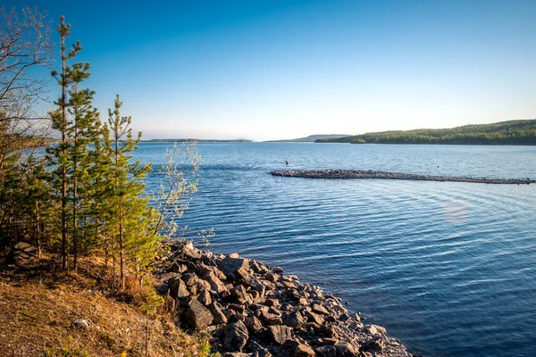 Old wooden boat sheds on Lake Kovdozero in the Murmansk region, Zelenoborsky village near Kandalaksha. The reflection in the water of trees and boat garages — Stock Photo, Image