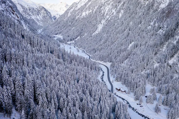 Widok z lotu ptaka na zaśnieżone sosny i mały meandrujący potok w Dolinie Stubai, Tyrol, Austria — Zdjęcie stockowe