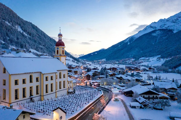 Paysage urbain du matin d'hiver dans la ville autrichienne de Neustift. Vue aérienne du centre-ville et de l'église. Éclairage matinal des maisons et des feux de circulation. Tyrol, vallée de Stubai — Photo