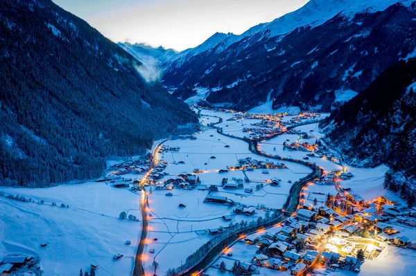 Krajobraz zimowej nocy w austriackim mieście Neustift. Widok z lotu ptaka na centrum miasta i kościół. Nocne oświetlenie domów i sygnalizacja świetlna. Tyrol, Dolina Stubai — Zdjęcie stockowe