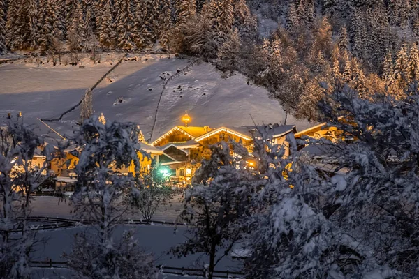 Paisaje nocturno de invierno con vistas a la ciudad austriaca tirolesa de Neustift, en el fondo de abetos en la nieve — Foto de Stock