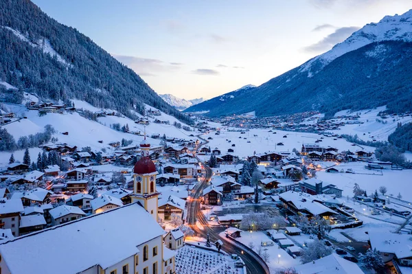 Paysage urbain du matin d'hiver dans la ville autrichienne de Neustift. Vue aérienne du centre-ville et de l'église. Éclairage matinal des maisons et des feux de circulation. Tyrol, vallée de Stubai — Photo