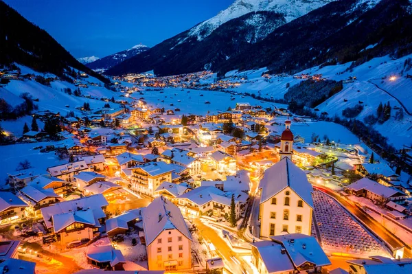 Winternachtelijk stadsgezicht in het Oostenrijkse Neustift. Uitzicht vanuit de lucht op het centrum en de kerk. Nachtverlichting van huizen en verkeerslichten. Tirol, Stubai-vallei — Stockfoto